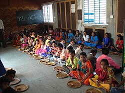 Children await school lunch in Rayka (also Raika), a village in Gujarat. The salutation Jai Bhim on the blackboard honours the jurist, social reformer, and Dalit leader B. R. Ambedkar.