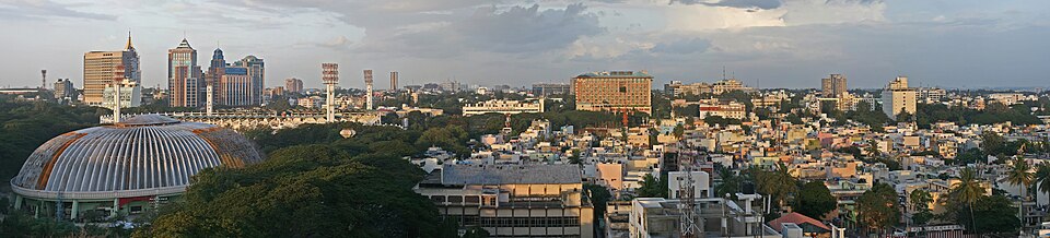 A panorama of Bangalore, the fifth-largest urban agglomeration. In the 1980s, when the first multinational corporations began to set up centres in India, they chose Bangalore because of the large pool of skilled graduates in the area, in turn due to the many science and engineering colleges in the surrounding region.